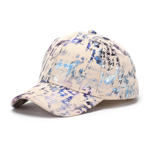 Close-up of beige suede baseball cap with blue and purple street style graffiti patterns