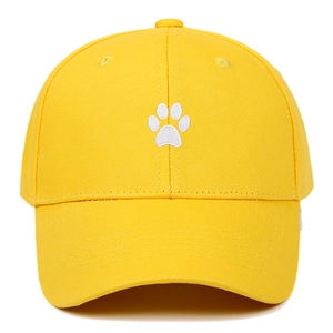 Detail view of white animal paw embroidery on yellow cotton twill baseball cap