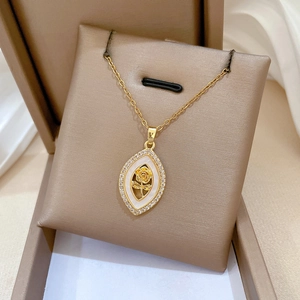 Détail du pendentif rose losange doré avec cristaux étincelants sur un support à bijoux