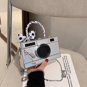 Silver camera shaped handbag with polka dot ribbon handle and metal chain strap