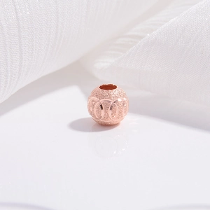 Macro shot of rose gold frosted star sand finish hollow olive beads for jewelry making