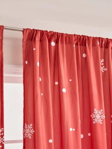 Detail of red Christmas curtain showing white snowflake patterns and rod pocket style