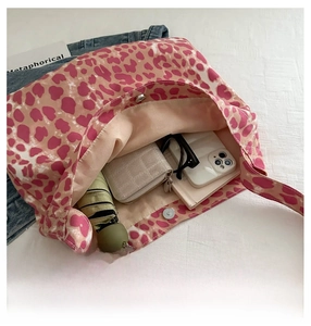 Detail view showing large interior capacity of leopard print tote bag with daily essentials