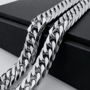 Detailed close-up of a silver stainless steel Cuban link chain with a polished finish