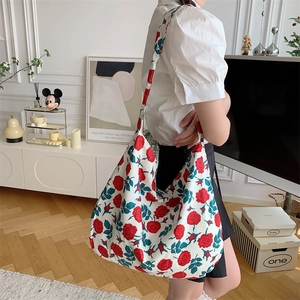 Detailed view of a large canvas tote bag with red rose floral pattern on a shoulder strap