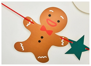 Detail of Christmas gingerbread man paper banner with green star and red ribbon