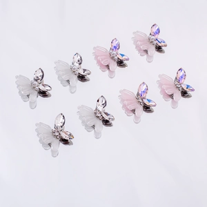 Macro shot of 3D resin butterfly nail charms with iridescent wings and pearl centers