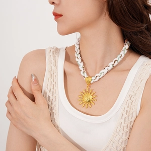 Detail of sun pendant necklace with white woven cord on female model neck