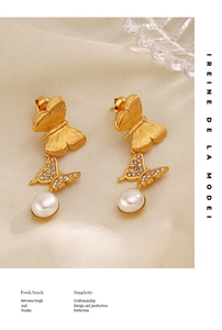 Detailed shot of gold butterfly earrings featuring sparkling zircon and round white pearls
