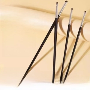 Macro shot of 4-piece pony hair eye makeup brushes with black handles and silver ferrules