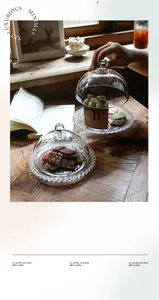 Detail of a clear glass dessert tray with dome lid and embossed dot trim on wood table