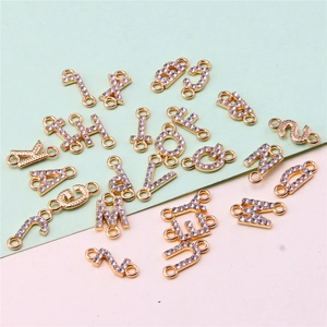Detailed view of gold alloy A-Z alphabet charms with sparkling rhinestones for DIY crafts