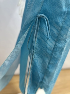 Detail view of blue snakeskin print chiffon dress featuring side tie-up and rolled edges
