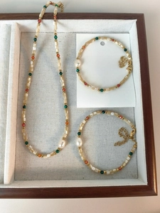 Detalle del conjunto de collar y pulseras con perlas de agua dulce y detalles de color