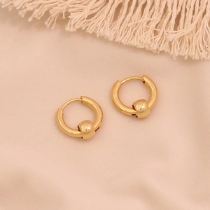 Detailed view of gold hoop earrings with sliding bead on elegant fabric backdrop