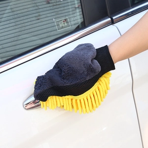 Close-up of a yellow chenille wash mitt wiping a white car door handle detail