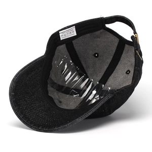 Detail view of the 100% cotton wash label and inner stitching of the black baseball cap