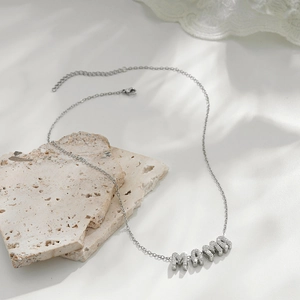 Macro view of silver MAMA letter pendant necklace with sparkling cubic zirconia inlay