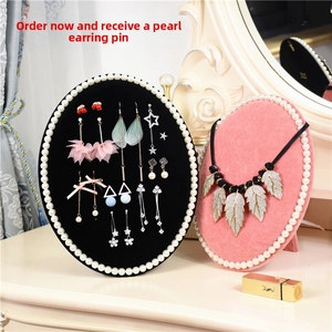 Macro shot of oval jewelry stands with pearl edges in pink and black velvet finish