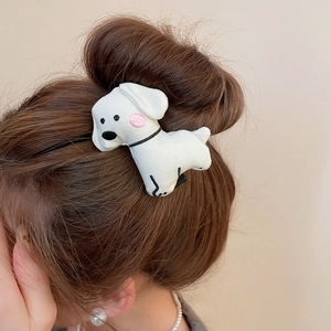Close-up of a plush white puppy hair clip with pink blush worn on a model hair side