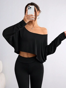Detail shot of black off-shoulder long sleeve top and slim leggings set in a mirror selfie