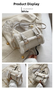 Detail view of white plush cylindrical handbag with buckle straps and gold hardware