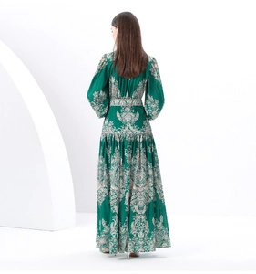Back view of a long dark green floral dress with lantern sleeves and a flowing hemline