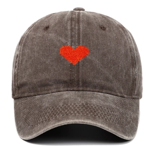 Detailed view of heart embroidery on washed cotton fabric of the vintage baseball cap