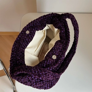 Dettaglio della borsa a tracolla in tweed viola con fodera crema e chiusura magnetica