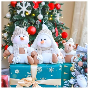 Christmas snowman and elk plush dolls with knitted scarves on a festive gift box