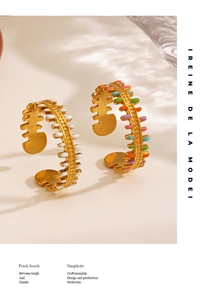 Detail of 18K gold-plated fishbone rings with colorful enamel on a soft ripple background