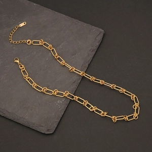 Detail of gold curb chain link necklace with lobster clasp and extension chain on slate
