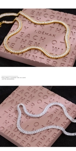 Close-up of gold and silver luxury zircon necklaces with rectangular step-cut gemstones