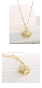 Detailed view of the gold shell pendant featuring a textured fan design on a beaded chain
