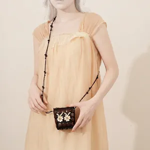 Handmade coconut shell woven mini crossbody bag with white flower bead accents