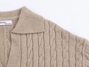 Detail of oatmeal cable knit polo sweater showing lapel collar and brand label