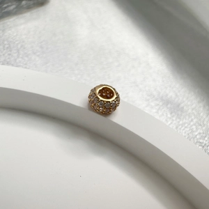 S925 sterling silver gold-plated spacer bead with pavé cubic zirconia on white stand