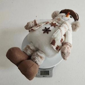 Detailed weight measurement showing a plush Christmas snowman doll weighing 398g on a scale