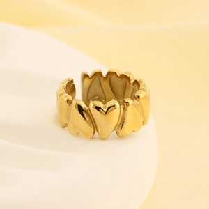 Macro detail of 18K gold plated heart ring with continuous heart patterns on white stand