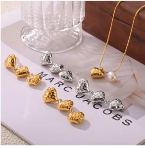Détails macro des pendentifs cœur dorés et argentés avec texture lave et perles