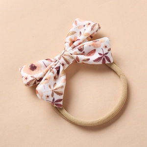 Close-up of floral bow baby headband featuring soft nylon elastic and rustic flower print