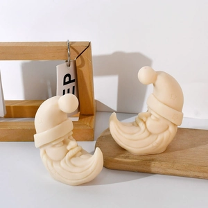 Macro shot of 2-piece cream Santa moon silicone candle molds with detailed carved textures
