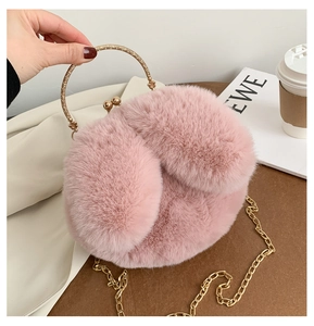 Detailed texture of pink faux fur plush bag with gold metal handle and metal clasp