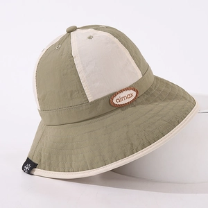 Detail of kids bucket hat featuring olive green color block and embroidered aimax patch