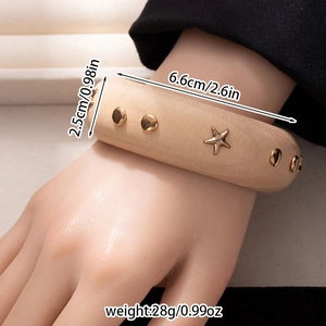 Detail view of wide wooden bangle with metal star rivets and dimension annotations