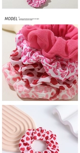 Detailed view of pink floral and heart print scrunchies showing soft fabric textures