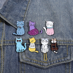 Cute cat enamel pins set featuring 1989 and Junior Jewels designs on denim jacket