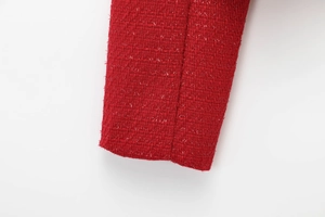 Close-up of red tweed fabric sleeve showing textured wool blend and shiny threads