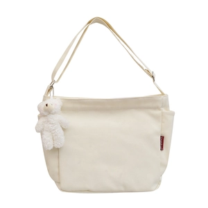 Minimalist cream canvas crossbody bag with adjustable strap and cute plush bear charm