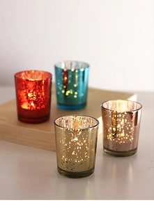 Macro shot of metallic mottled glass candle holders in gold, rose gold, red and blue